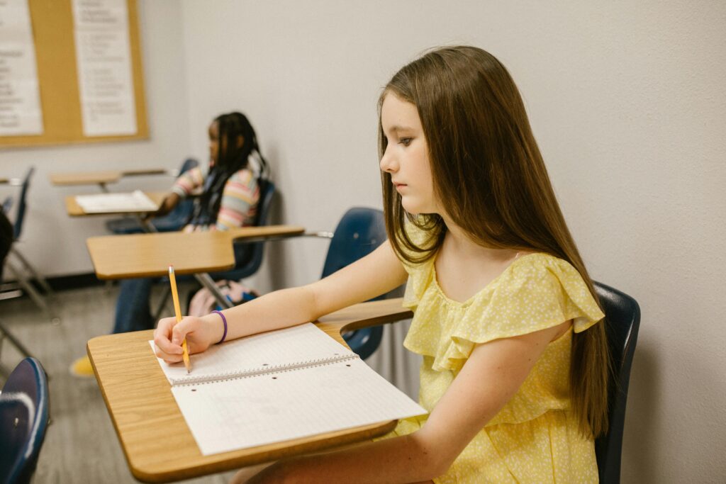 Girl wearing a yellow dress, writing and thinking