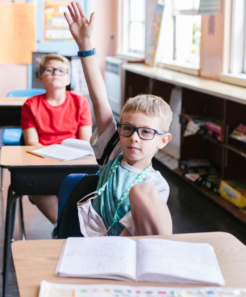 Student raising his hand attentively,